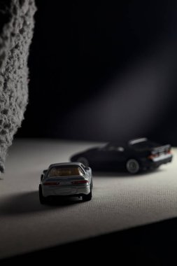 Mantova, İtalya - 3RD JANUARY 2025 - 1989 Mazda Savanna RX-7 'nin Ateşli Tekerlekleri ve Kibrit kutusu kopyaları ve beyaz bir tahtanın üzerinde beyaz bir kumaş parçasının yanında, uçurumun kenarındaki bir dağ yolunda yarış yapıyormuş gibi yapan Mitsubishi 3000 GT