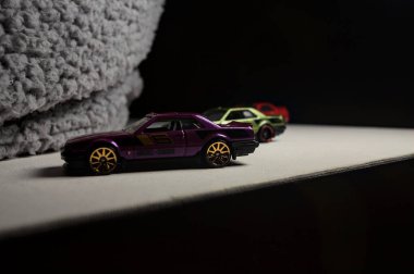 Mantova, İtalya - 3RD JANUARY 2025 - Nissan Skyline modellerinin çeşitli kopyaları, iki R30, bir GT-R R32 ve bir GT-R R33, beyaz bir tahta üzerinde, gri bir kumaş parçasının yanında, uçurumun kenarındaki bir dağ yolunda yarış yapıyormuş gibi yaparak