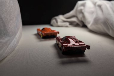 Mantova, İtalya - 4. HAZİRAN 2025 - Beyaz güvertede beyaz kumaşlarla çevrili iki Mazda 787B yarış elbisesinin Sıcak Tekerlekleri kopyaları, yolda bir kıvrım yapar ve aralarında bir yarış varmış gibi davranıyorlar.