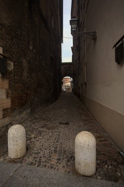 Dar patika, biraz gölgede, üzerinde bir geçit var.