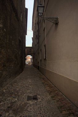 Dar patika, biraz gölgede, üzerinde bir geçit var.