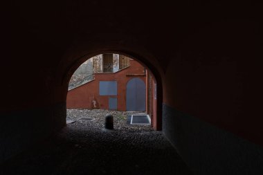 Alçak bir kemerin altından geçen bir sokak, bir İtalyan kasabasında.