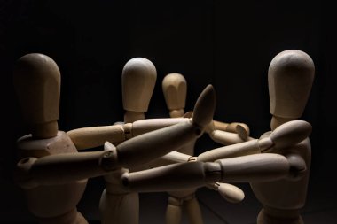 Tahta manken kollarını açıyor ve diğer üç tahta mankene karşı duruyor. Kollarını sabit tutana karşı koyuyorlar.