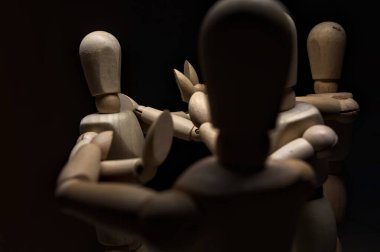 Tahta manken kollarını açıyor ve diğer üç tahta mankene karşı duruyor. Kollarını sabit tutana karşı koyuyorlar.