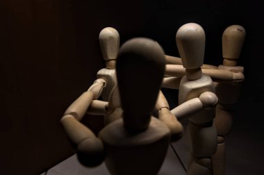 Tahta manken kollarını açıyor ve diğer üç tahta mankene karşı duruyor. Kollarını sabit tutana karşı koyuyorlar.