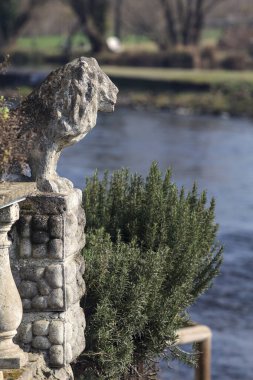 Nehir kenarındaki aslan heykeli. Arka planda nehrin kendisi var.