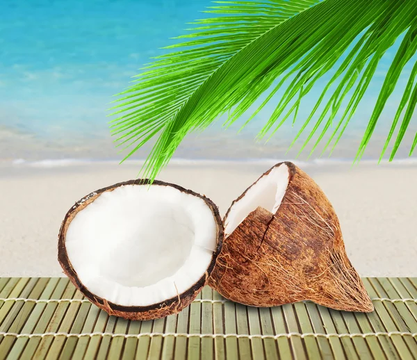 Zwei Hälften Kokosnuss auf Strandhintergrund — Stockfoto