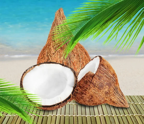 Kokosnüsse mit Blatt auf Strandhintergrund — Stockfoto