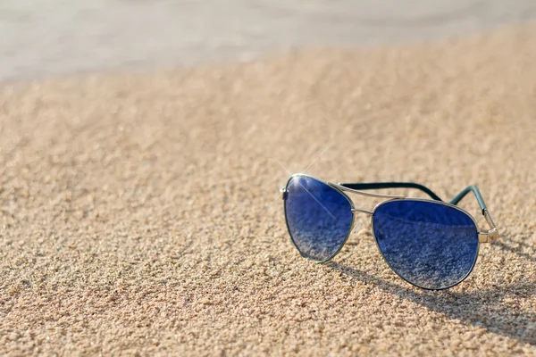 Solglasögon på en sand — Stockfoto