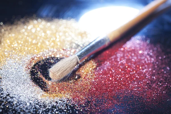 Close-up on makeup brush and colorful shining powders — Stock Photo, Image