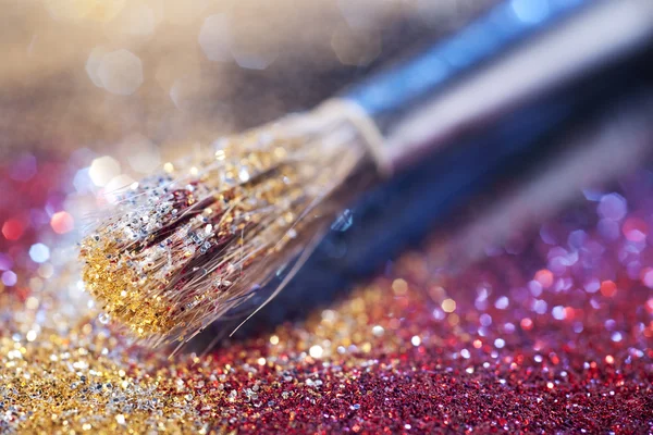 Close-up on makeup brush and colorful shining powders — Stock Photo, Image