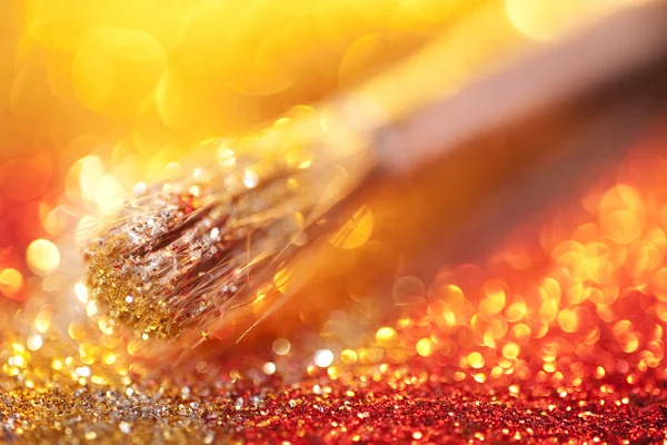 Close-up on makeup brush and gold shining powder — Stock Photo, Image