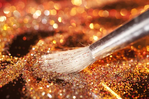 Nahaufnahme auf Make-up-Pinsel und goldglänzendem Puder — Stockfoto