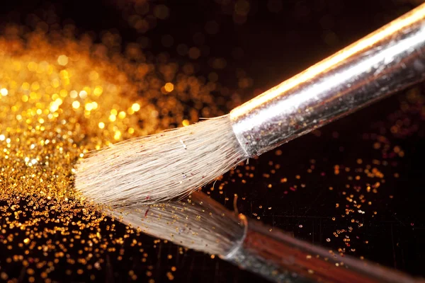 Close-up on makeup brush and gold shining powder — Stock Photo, Image