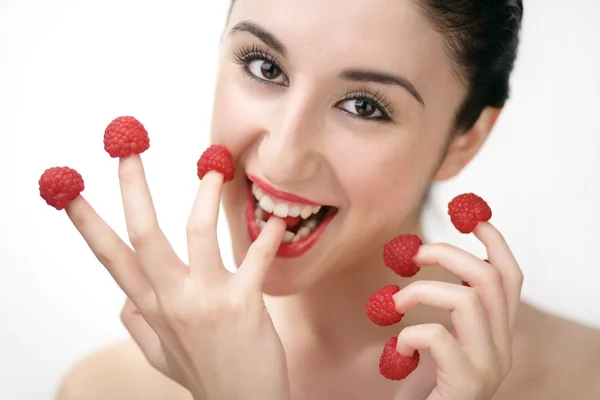 Young sexy woman eating raspberries off fingers — Stock Photo, Image