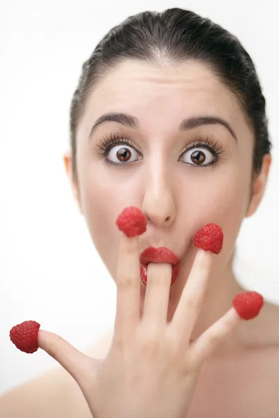 Jovem sexy mulher comer framboesas fora dedos — Fotografia de Stock