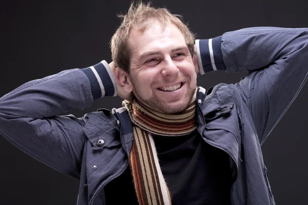 Portrait of young smiling man with a jacket and scarf — Stock Photo, Image