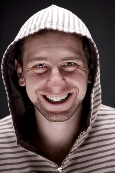 Portrait of young smiling man with a hood — Stock Photo, Image