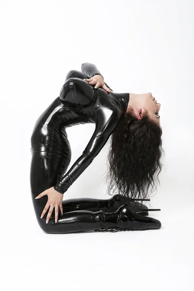 Sexy flexibele brunette vrouw in zwarte latex. Hoge hakken — Stockfoto