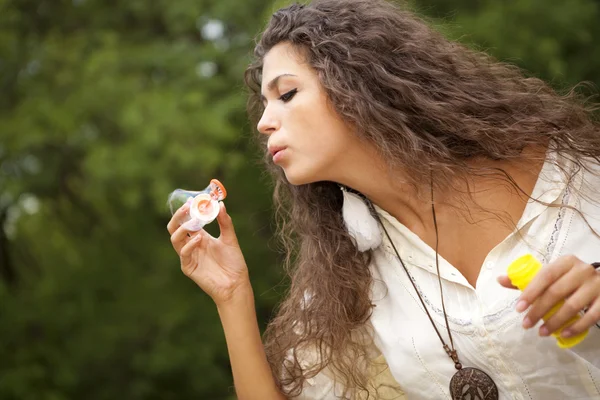 Schöne Hippie-Mädchen im Park bläst Blasen — Stockfoto