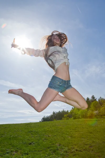 Досить босоніж жінка стрибає високо в парку — стокове фото