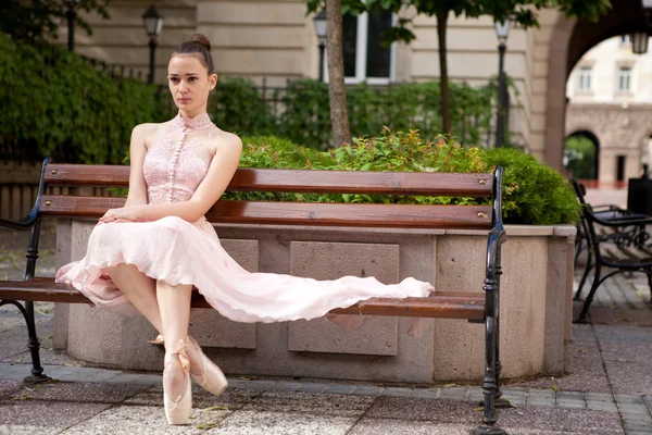 Jovem bela bailarina relaxante no banco — Fotografia de Stock