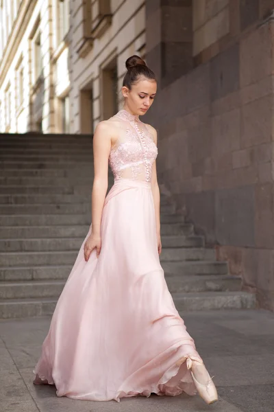 Ung ballerina med smuk lyserød kjole poserende udendørs - Stock-foto