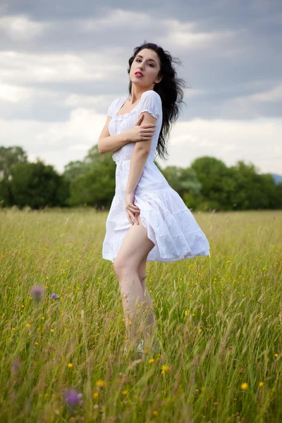 Sexy jovem mulher vestindo vestido branco no campo de grama — Fotografia de Stock