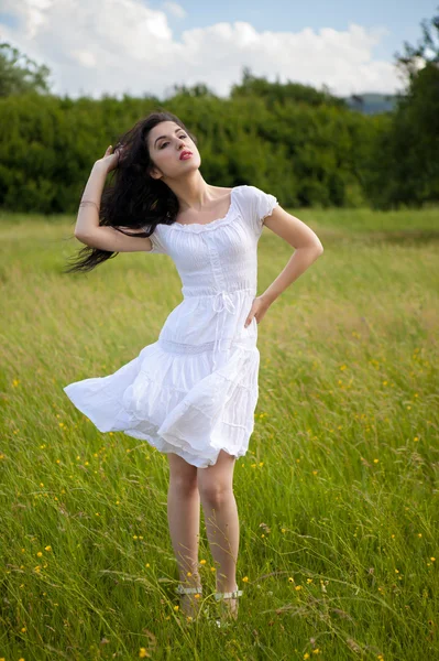 Szexi fiatal nő visel fehér ruhában, füves területen — Stock Fotó