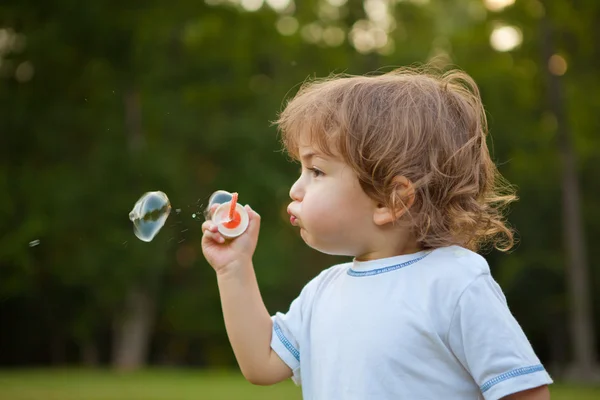 Szappanbuborék fújás parkban kisfiú — Stock Fotó