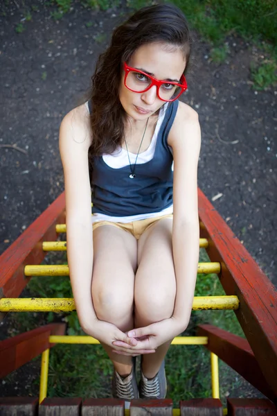 Jovem no parque infantil relaxante — Fotografia de Stock