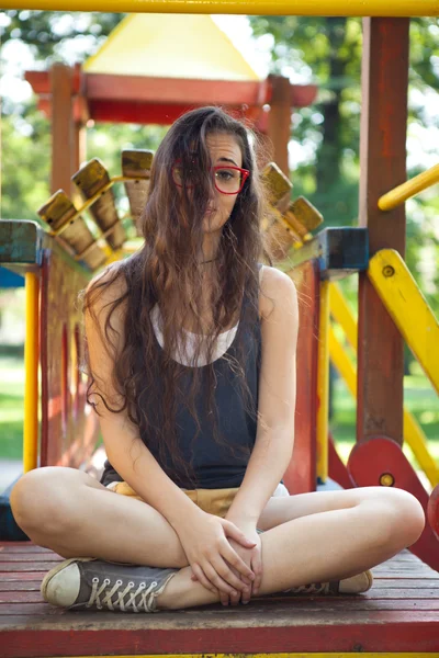 Jovem no parque infantil relaxante — Fotografia de Stock