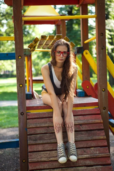 Jovem no parque infantil relaxante — Fotografia de Stock