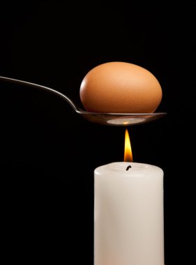 Mum üzerinde gümüş kaşık duman kahverengi yumurta sarılı