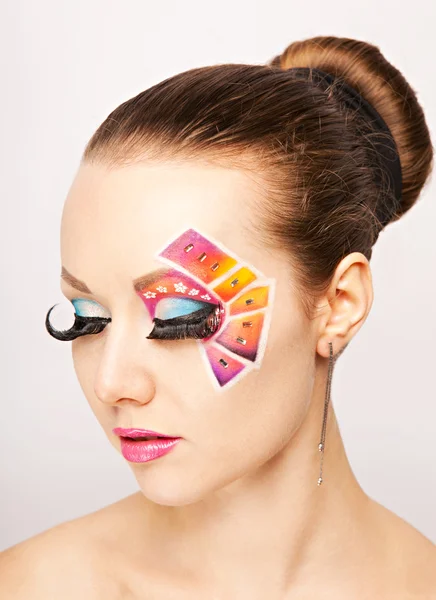 Donna con trucco creativo colorato utilizzando ciglia finte — Foto Stock