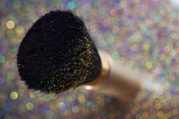 Closeup on makeup golden brush and shining powder — Stock Photo, Image