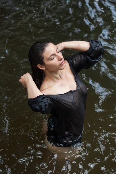 Sportieve brunette vrouw in een rivier — Stockfoto