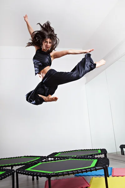 갈색 머리 여자는 트램 폴 린에 점프 — 스톡 사진