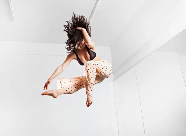 Saltando jovem mulher em um trampolim — Fotografia de Stock