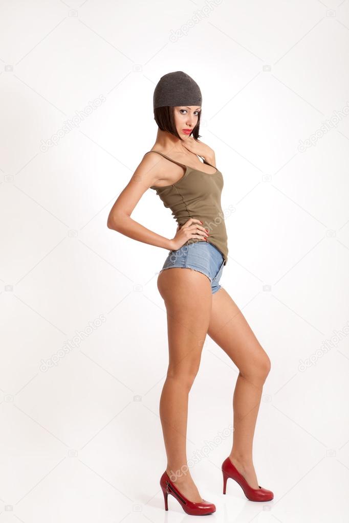Sexy woman with short jeans, hat and red high heels