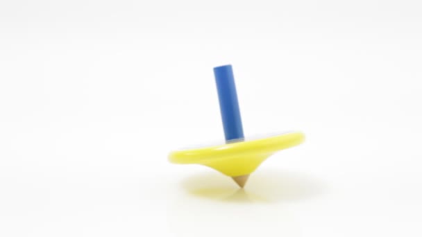 Wooden spinning top painted in yellow and blue colors — Stock Video