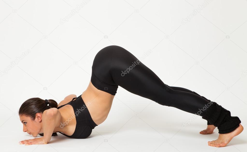 Sexy fit brunette woman in sportswear doing yoga exercises Stock Photo by  ©RVAS 77043615