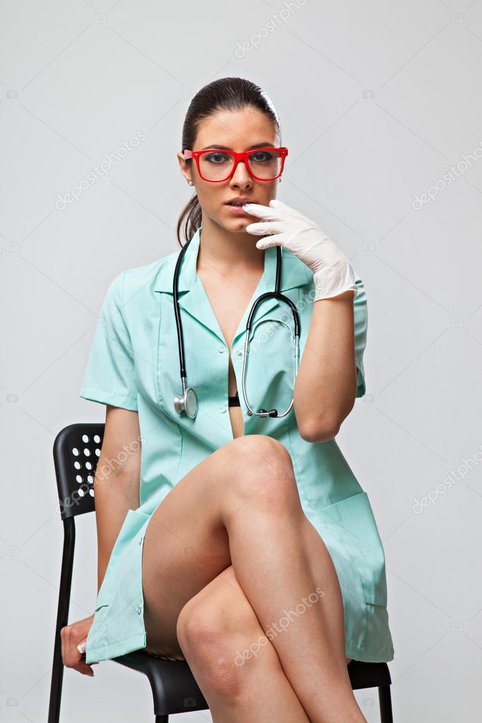 Sexy woman doctor with a stethoscope and red glasses sitting on chair Stock Photo by ©RVAS 83317320 pic
