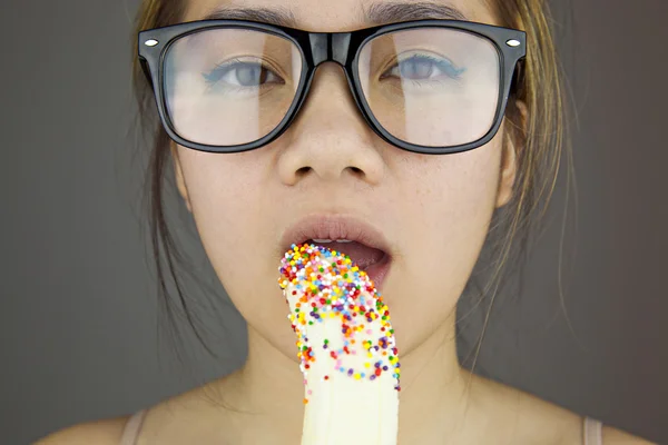 Beautiful woman with black sunglasses sexy eating banana. Studio shot — Stock Photo, Image