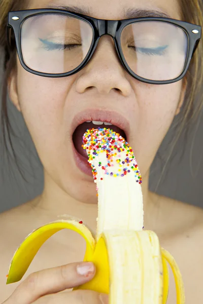 Όμορφη γυναίκα με μαύρα γυαλιά ηλίου σέξι τρώει Μπανάνα. Studio που γυρίστηκε — Φωτογραφία Αρχείου