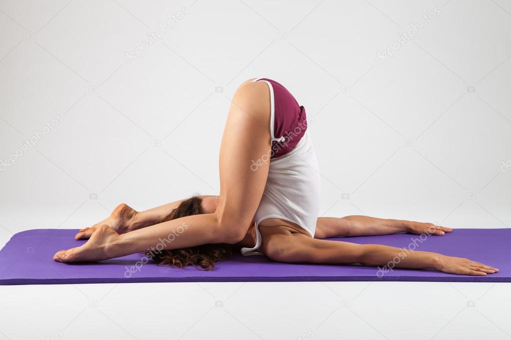 Sexy woman doing yoga exercises Stock Photo by ©RVAS 90484036
