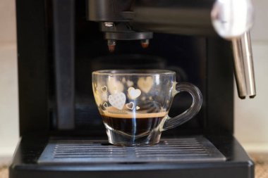 kahve makinesi çalışıyor ve ürünü dağıtıyor.