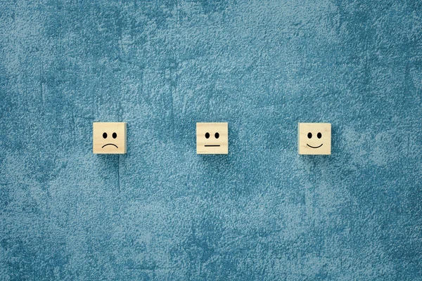 不同的情绪在蓝色背景的木制立方体上表现出来 用于满意度调查 心理健康评估 — 图库照片