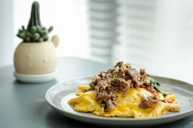 Kızarmış Tayland usulü fesleğenli biftek ve üzerine de pirinç, sıcak ve baharatlı Tayland yemeği.