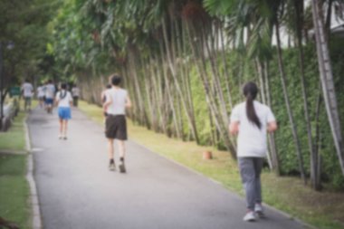 Yeşil parkta koşan insanların bulanık görüntüsü, sağlık ve yaşam tarzı konsepti